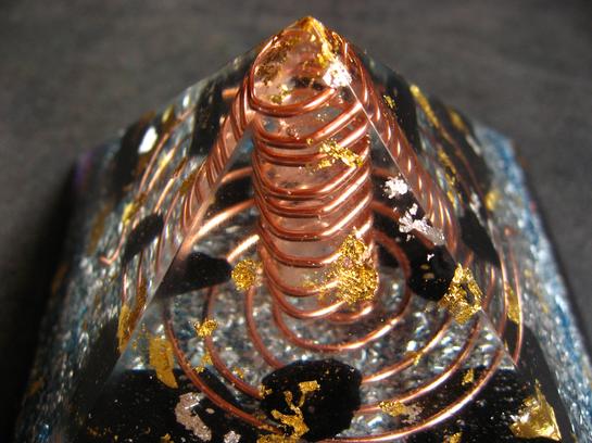 <h1>Pyramide Nombre d'Or</h1><br/><h4>11cm de Base, 7cm de Hauteur, poids 400g.<br/><br/> Composée de Shungite, Tourmaline, Imprégnée des Flammes Violette et Bleue.<br/><br/>Intense générateur de Prana amplifié par l'Onde de Forme, Grande Protection contre les Ondes, idéale pour les Pièces de Vie, Bureau...<br/><br/>Magnifique Encrage par action sur les Chakras de Base et Sacré<br/>Pour Ma part, En Méditation, elle m'isole d'une façon extraordinaire du Monde extérieur, en établissant une Barrière autour du corps. Le Lâcher-prise est nettement Facilité, les Sensations Grandement Amplifiées...</h4>